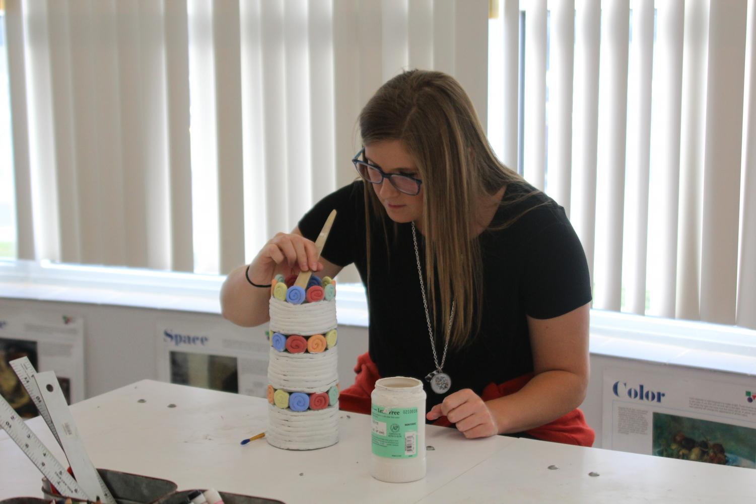 Art teacher Whitney Long glazes her coil pot during second hour. She often does projects with her students.