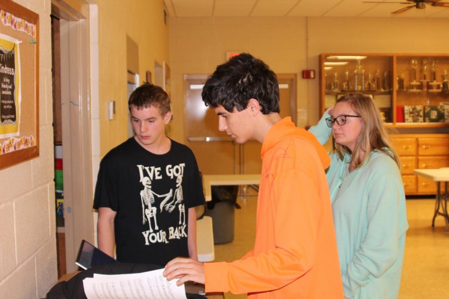 At an afternoon practice at the Catholic church, sophomore Dakota Beck, junior Neal Zoglmann and Paige Lange decide on music for Christmas. 