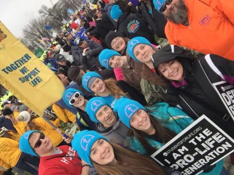 The March for Life group gather together during the march for a group photo. The Conway students are in blue hats with Becky Heimerman in a black coat next to them. 