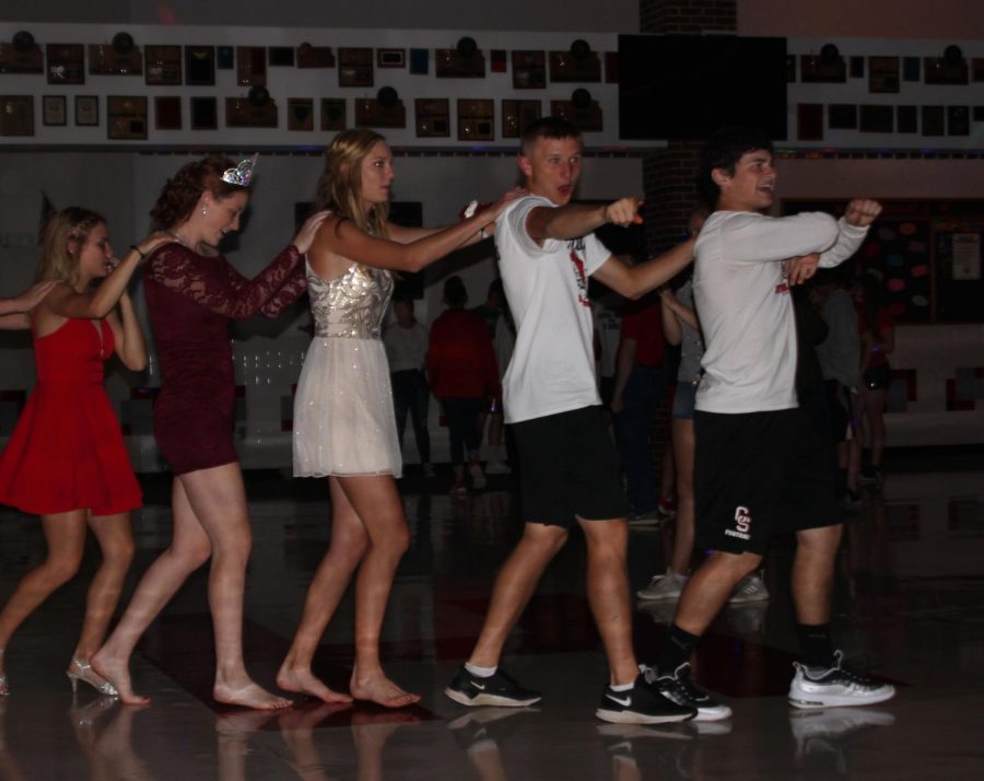 The Homecoming senior candidates Seth Osner, Peyton Winter, Kara Koester, Madison Pauly and Reagan Ebenkamp lead a conga line around the dance floor. “Being queen makes everyone think you’re popular and everyone wants to take pictures with you, which is kind of unnerving. It made it more fun than the previous years, though, because I got to talk to people I don’t usually,” Pauly said.