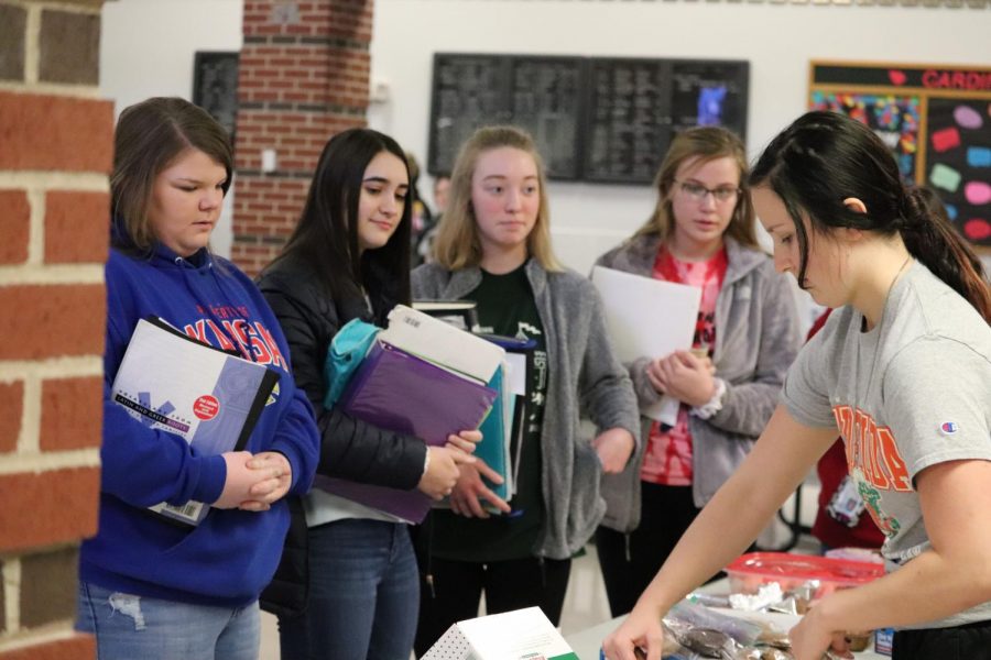 Senior Karley Mooneyham hands out treats to juniors Addie Barkley and Molly Bender, and sophomores Rosalyn Zoglmann and Abby Botkin.  All proceeds went to helping the animals and people in need. 
