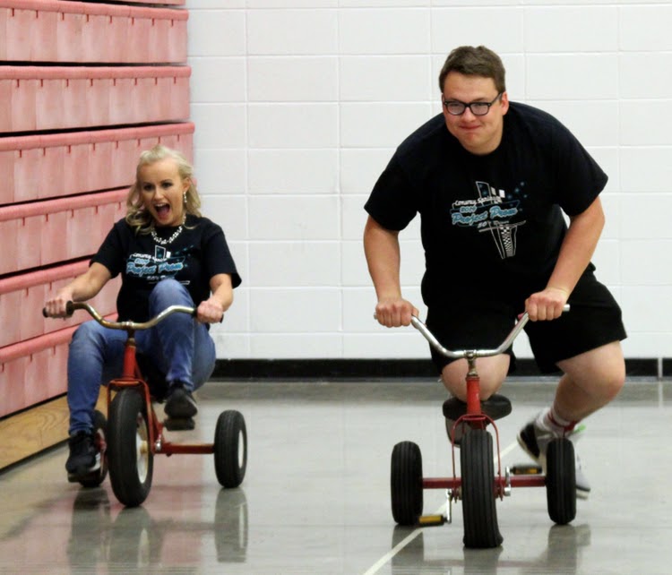 At the 2019 After Prom, juniors Amy Zoglmann and Dawson Martin ride tricycles for a game. Last year’s After Prom was held at the high school with various activities put together by the Project Prom committee.