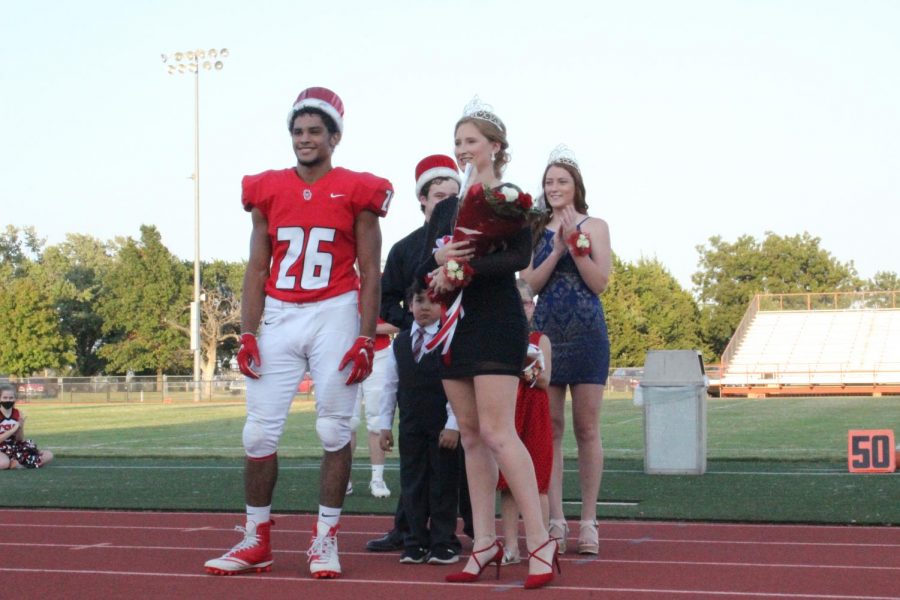 Seniors Tatum Wykes and Jonathan Wright smile as friends and family applaud for them after getting homecoming king and queen. Former king Philip Ast and queen Madison Pauly stood with kindergarteners Cooper Nichols and Avery Cox congratulating them on their win. 
