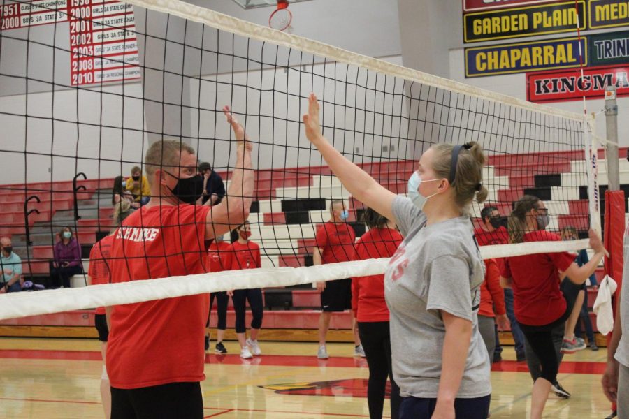 After the volleyball games were over, senior Sadie Schmanke gives her father and second grade teacher Keith Schmanke an air high five through the net. This took place during the senior faculty games in the high school gym March 30.