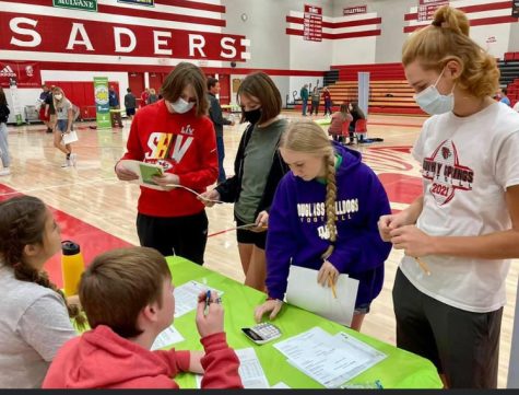 At Wellington High School Oct. 14, sophomores Aiden Dalbom, Kira Forrest, Makenna Wylie and Taylor Wykes participate in the Reality U event. At this station, they learned the cost of child care.
