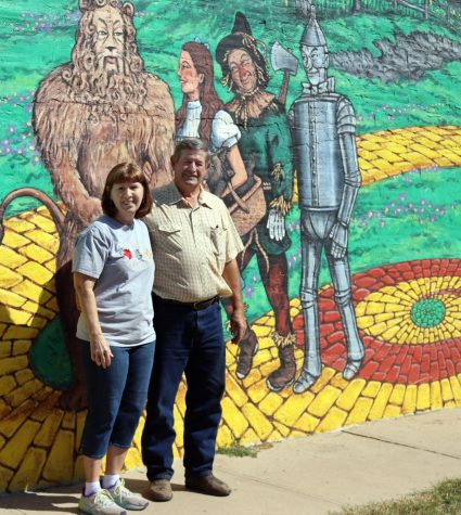 Parade Marshalls Albert and Evelyn Osner stand in front of mural on the side of Osner Upholstery. This is one of their many businesses they own. 