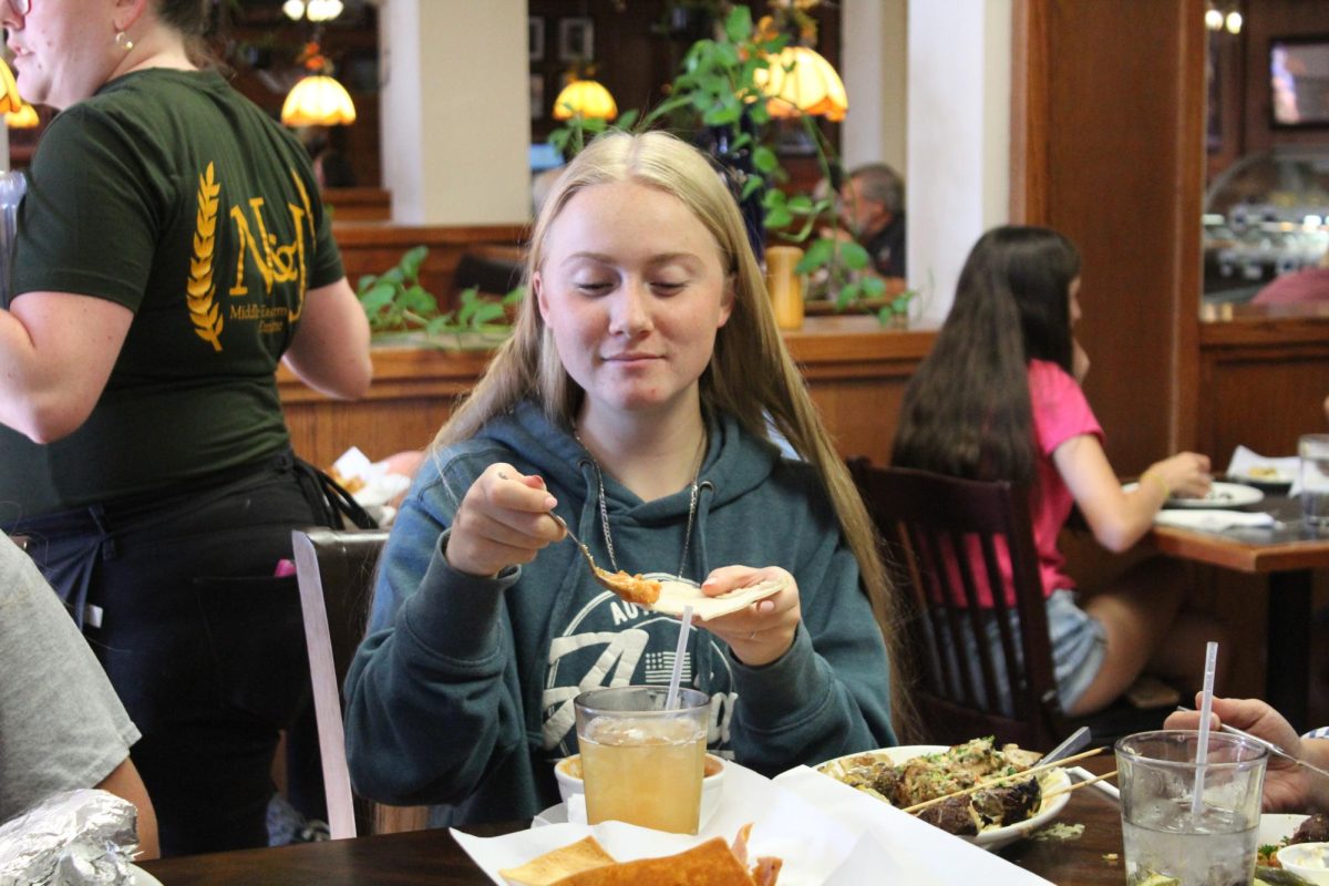 Senior Makenna Wylie enjoys her food. She ordered a platter, which included many different foods. 
