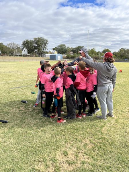 Coaches Taylor Wykes and Cade Howell circle up with their flag football team. They shared a team chant after the last game of the season. 
