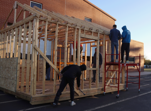 In Ag Mechanics, sophomore Eli Benge hammers on the ground while senior Brayden Kunz and junior Evan Lange are up on scaffolding. The class was building the shed for the OWL site.