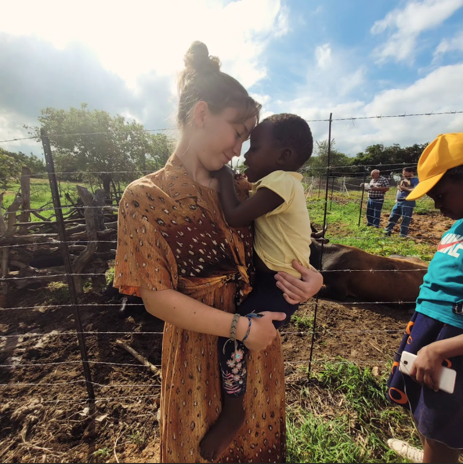 Sophomore Anna Bender hugs a child from the village of Arnoldine Mission. Both Anna and her sister, senior Grace Bender, were able to spend time with the children by playing games and learning about their culture. 
