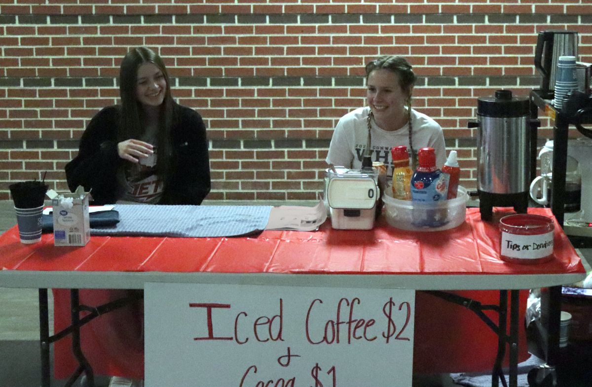 Outside the basketball court, senior Taylor Heinz and junior Jan Stuhlsatz sell iced coffee and hot cocoa. Stuhlsatz raised money for the Mission Mart for her and junior Lacey Kelly’s FCCLA Star event. 
