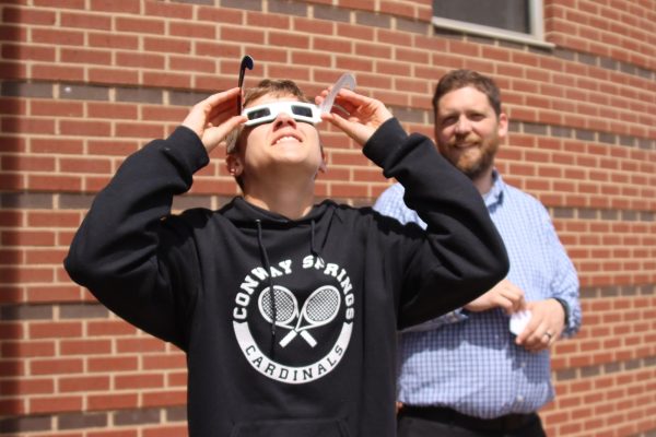 Freshman Ian May and math teacher Nick Ulrich view the solar eclipse. Students got the special solar eclipse glasses from teachers. 
