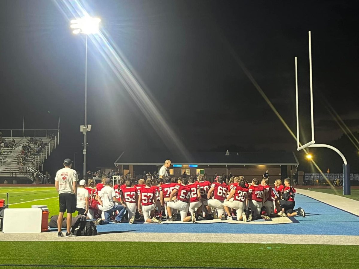 The football team gathers around head coach Matt Biehler for a prayer and a motivational speech after the game. This has been a tradition for many years. 
Photo contributed by Melissa Winter