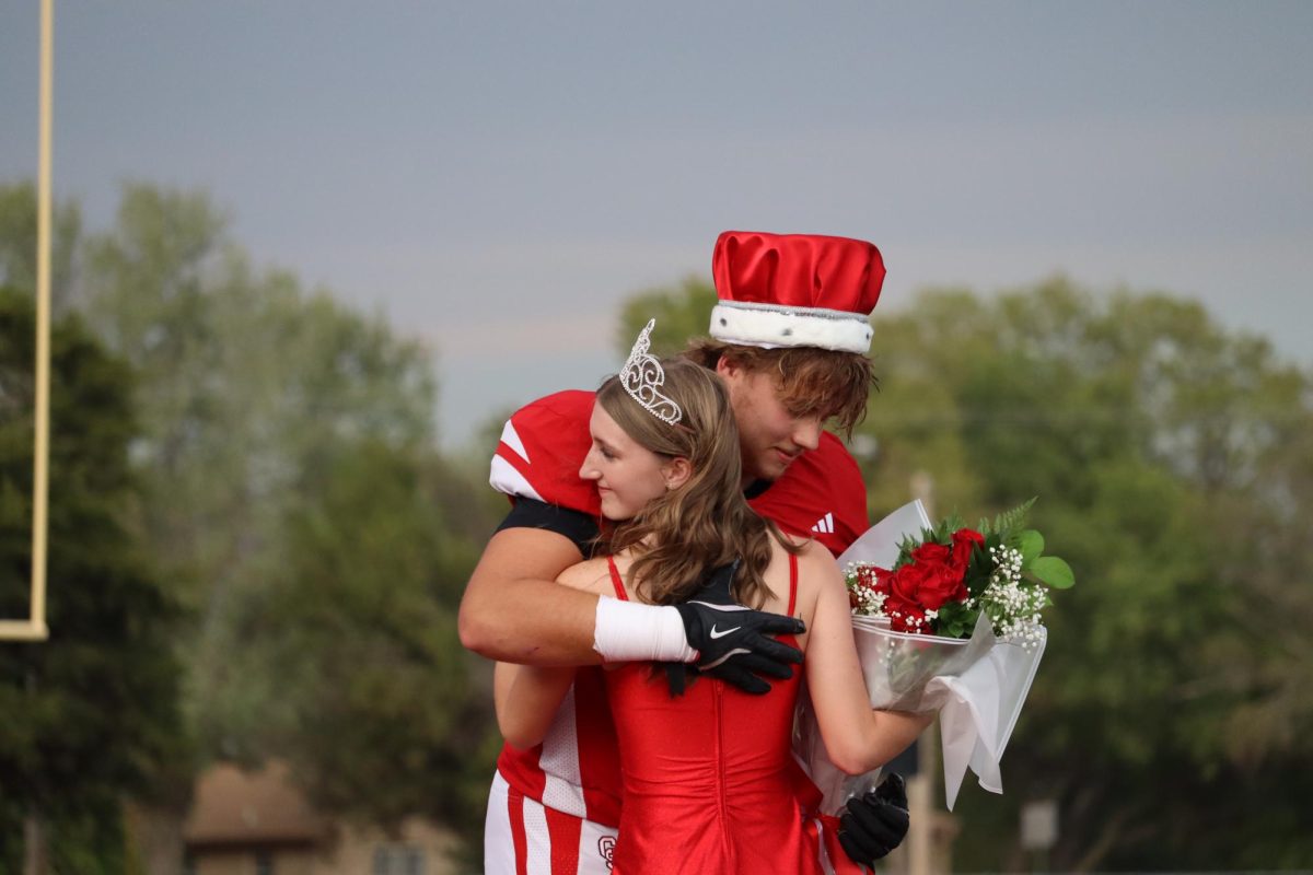 The fall homecoming ceremony went great. Students senior Regan May and senior Cooper Koster share a hug as prom king and prom queen.