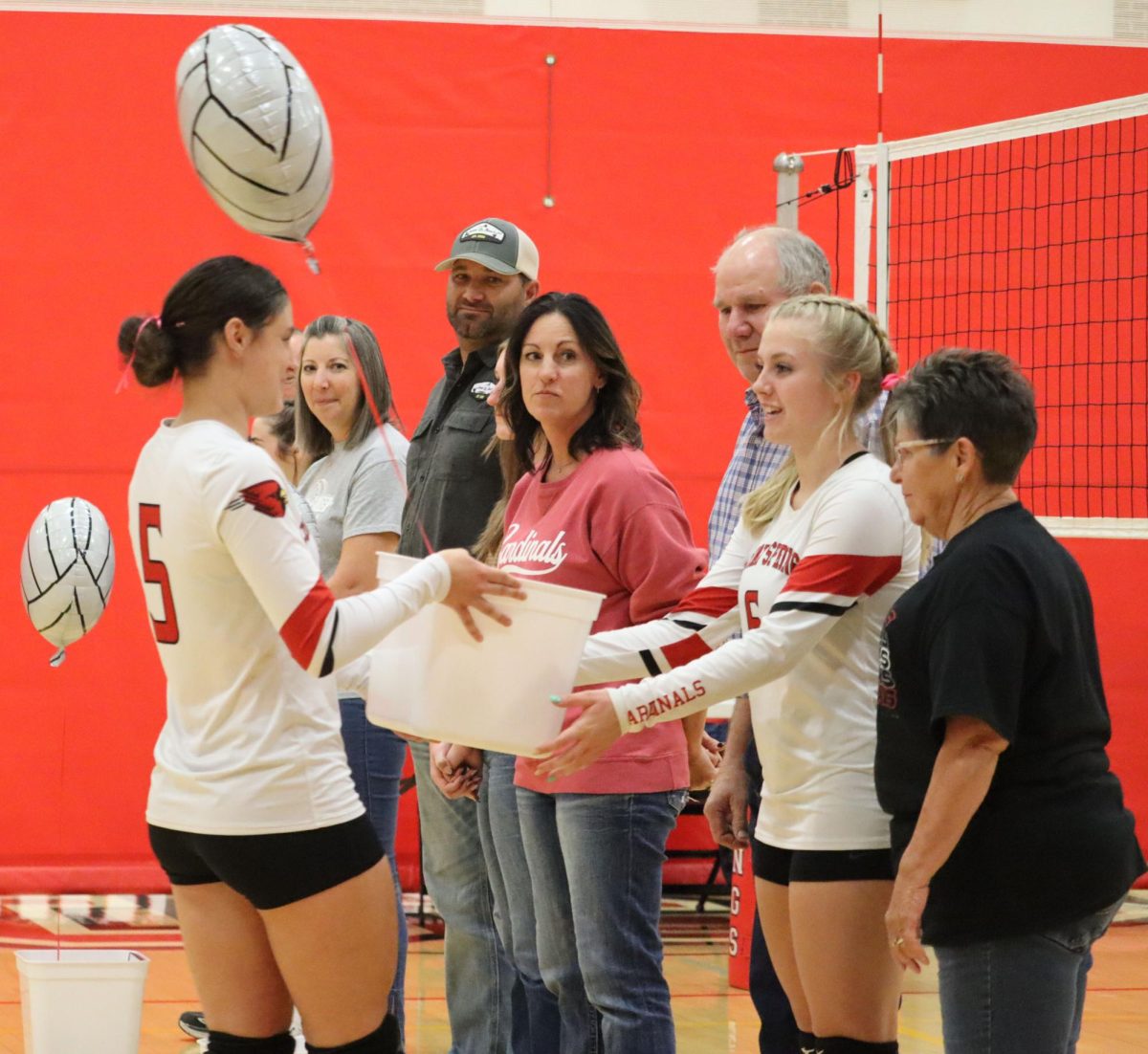 Sophomore Delaney Jones gives senior Ava Daniel a gift basket at senior night Oct. 1. Seniors received letters from all the underclassmen, along with an etch a sketch, drinks and candy. 
