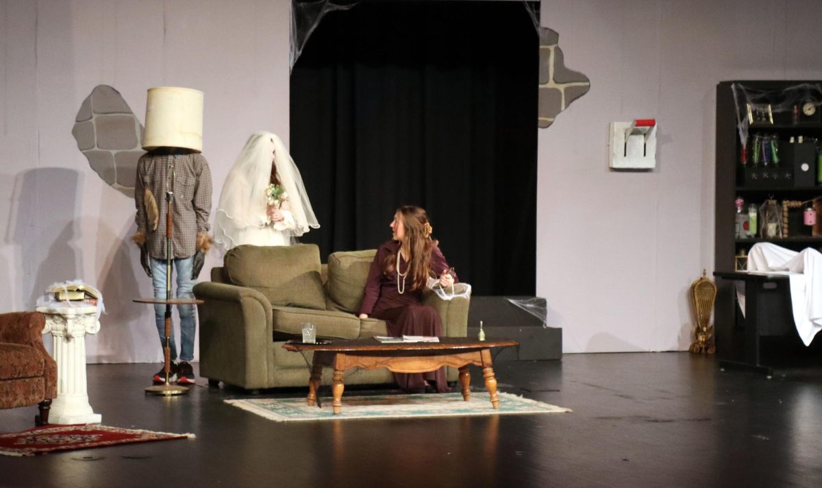 At the fall play, Frankenstein Slept Here on Nov. 16 & 17 senior Gabe Murphy hid under a lamp as senior Addie Pauly and junior Bethany Hollis conversed.