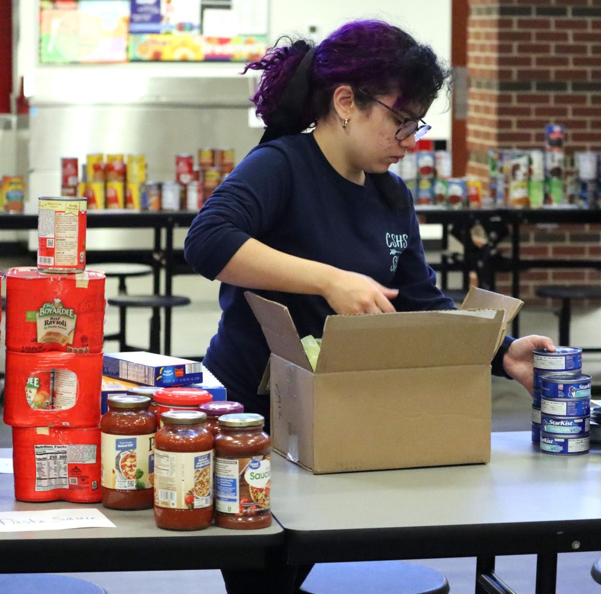 During the can sorting, Senior Faith Rivera takes cans out of boxes. Rivera was sorting the canned fish. 