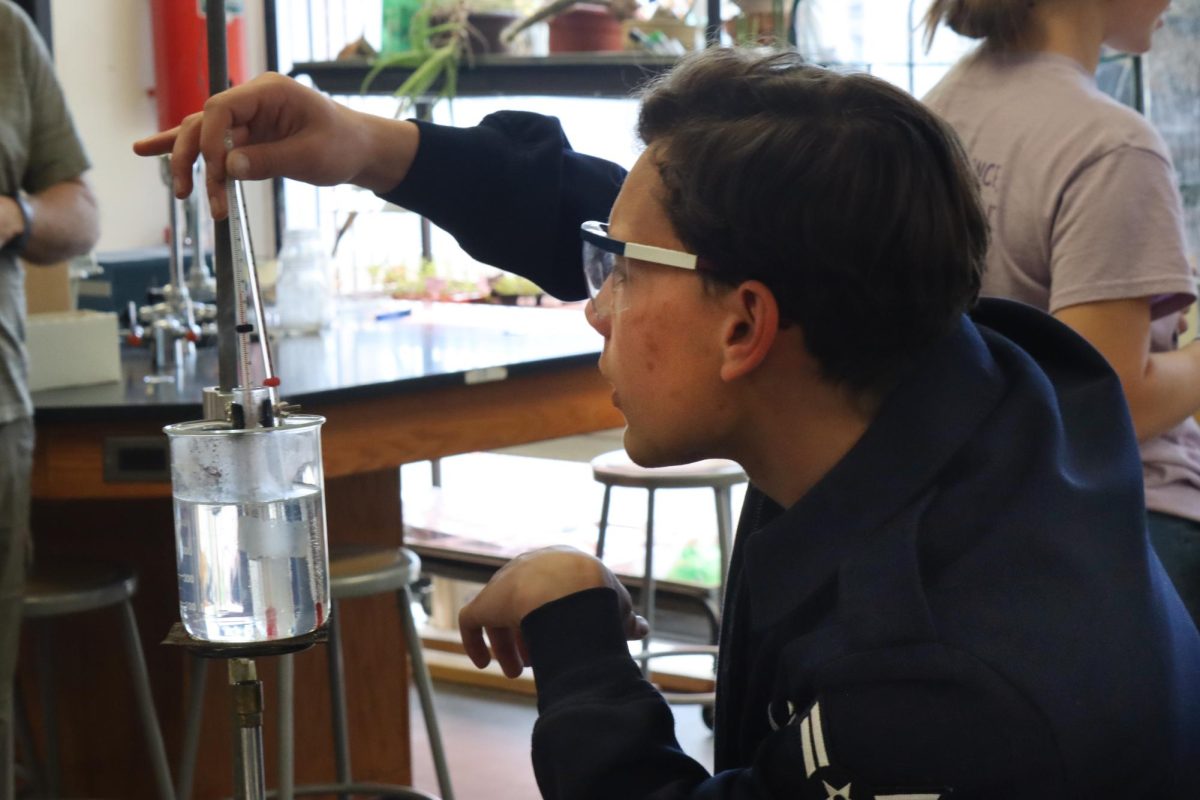 Junior Sylvester Hemberger checks the temperature of water for his lab. This was during 5th hour chemistry class. 