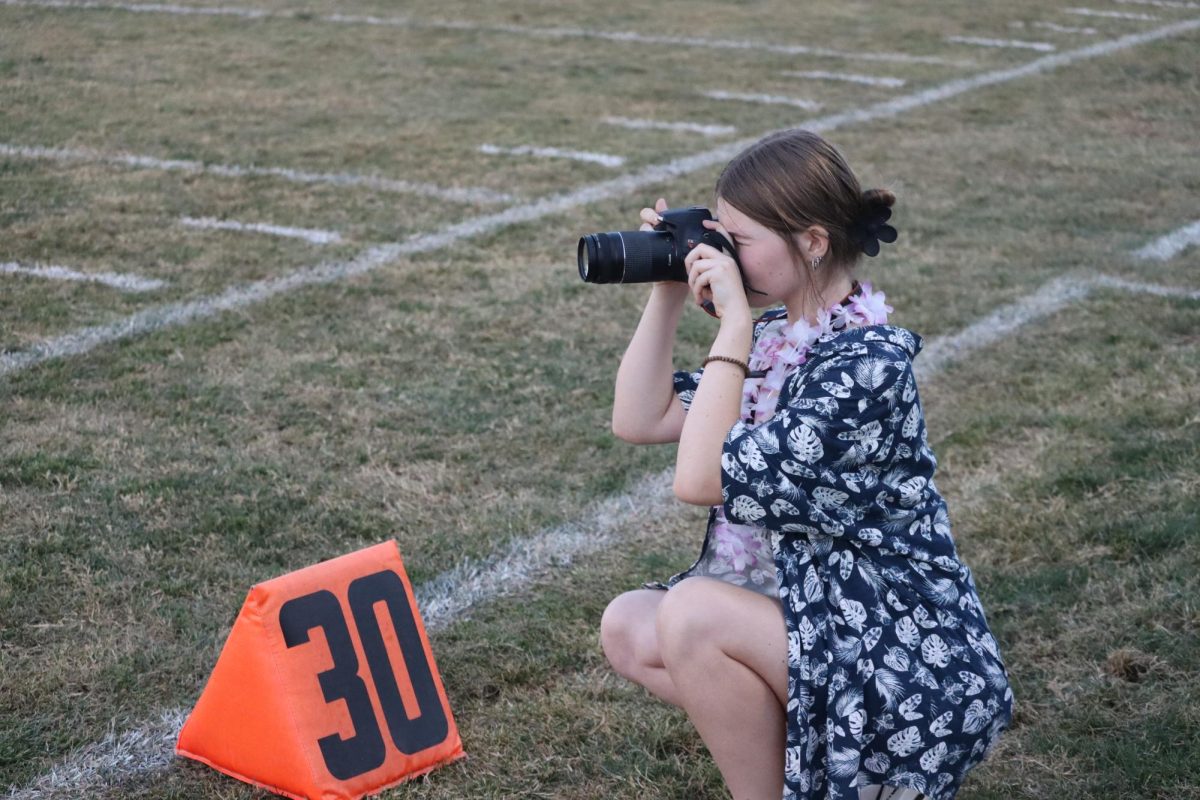 At an away football game sophomore Sophy Dalbom takes pictures for the yearbook. At least one photographer was at every home football game this season.