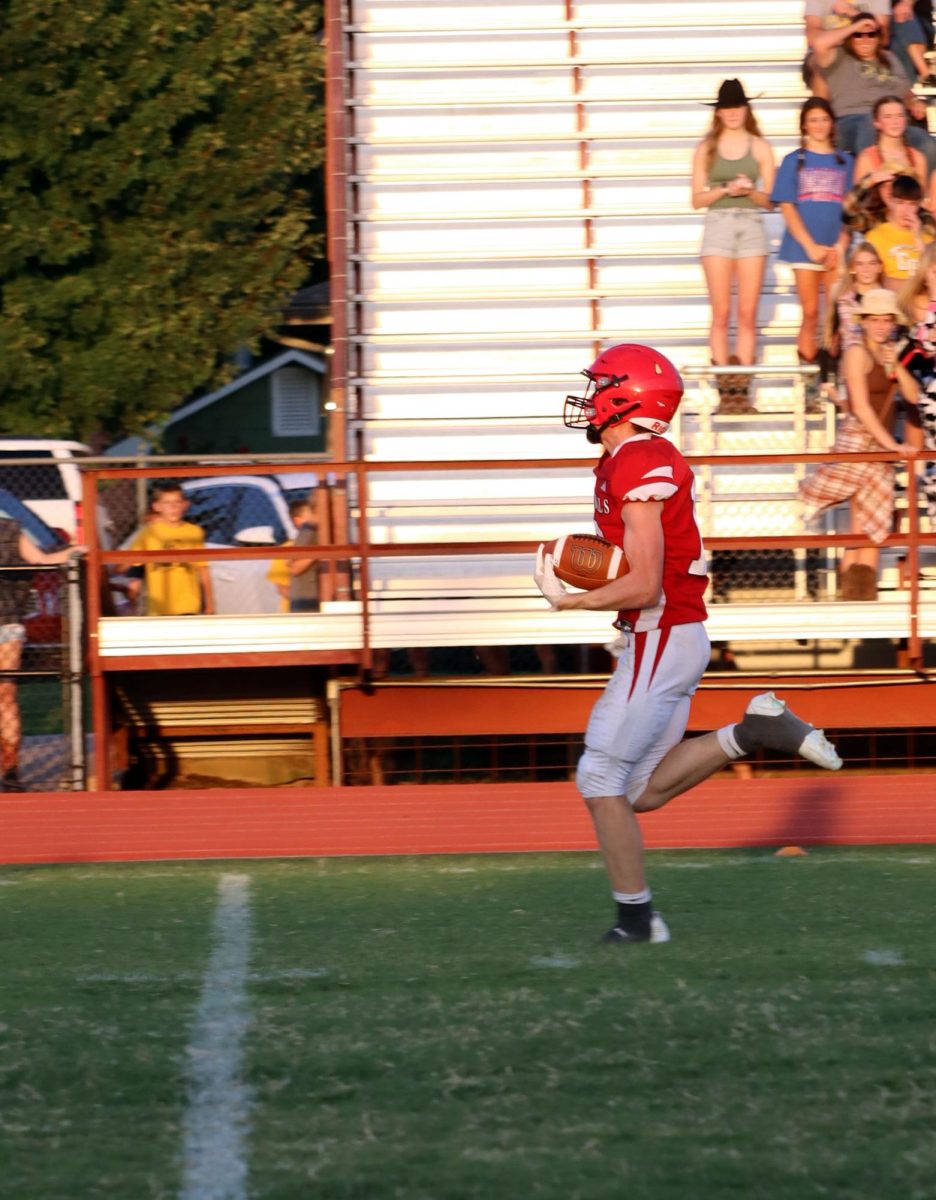 On Sept. 12, senior Logan Osner runs toward the 35 yard line, about to make the first touchdown of the night. The Cardinals lost to the Garden Plain Owls 14-33.