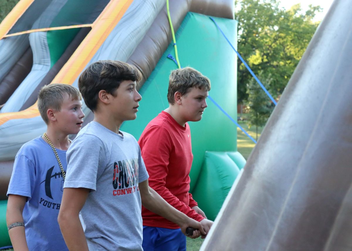 At the inflatables during Fall Fest, sophomore Gus Hemberger supervises younger kids. Stuco sponsored the inflatables.