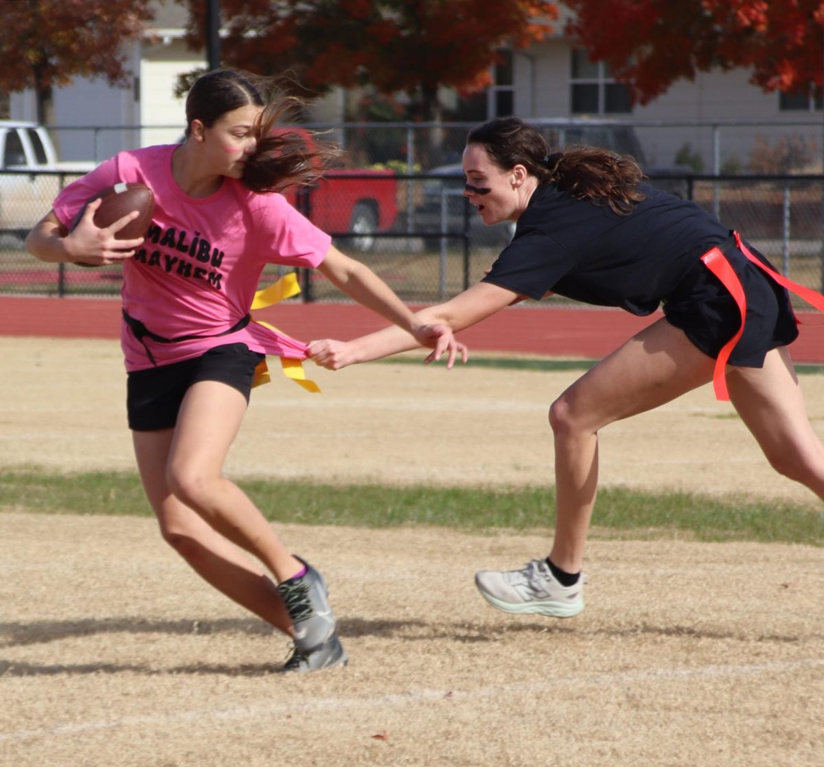 At the football field, freshman Klara Ast jukes senior Miley Pauly. Ast's flag was pulled by senior Morgan Koester ten yards later. 