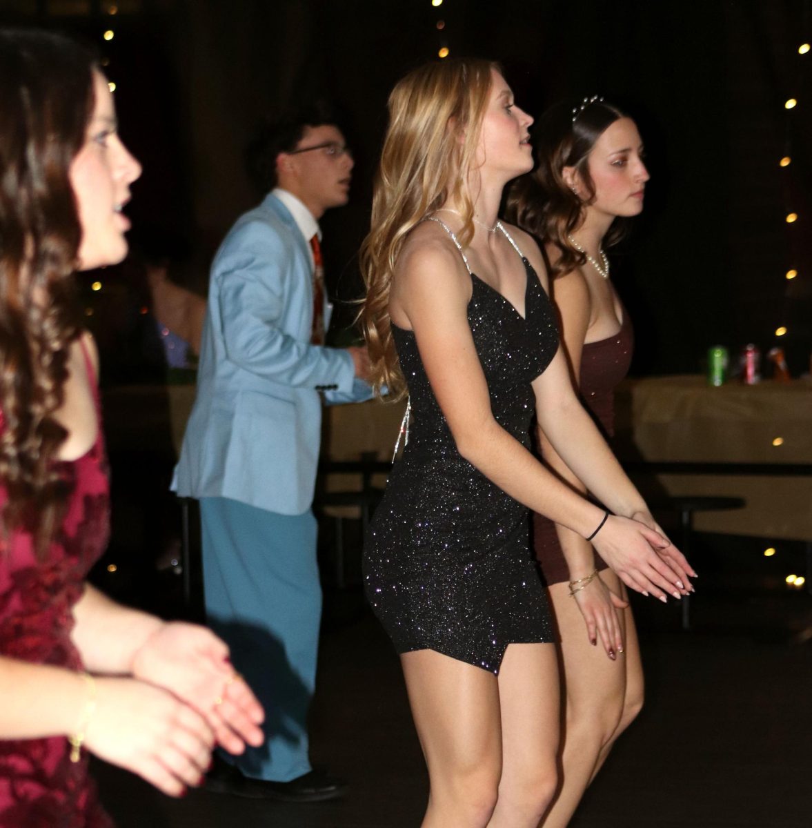 On the dance floor, senior Sylvester Hemberger, sophomore Jade Erker and junior Adysen Conkle clap and dance to a song.