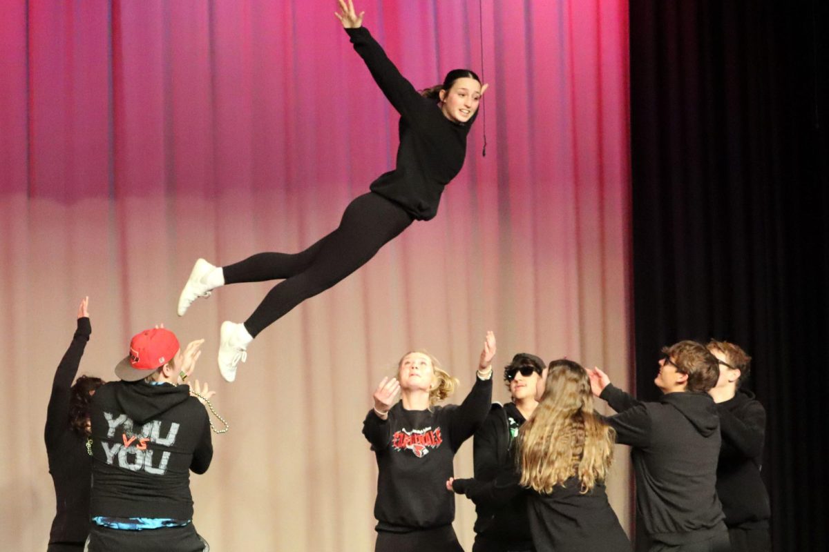 As junior Adysen Conkle is flying through the air, her classmates are beneath her ready to catch her.