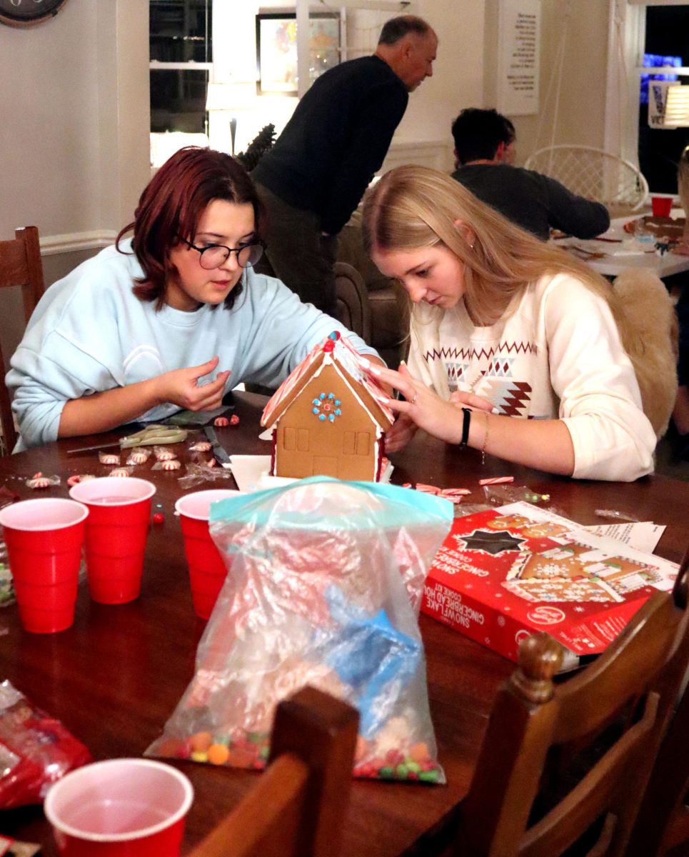 Seniors Aliette Potts, and Reece Johnson build a gingerbread house together.
